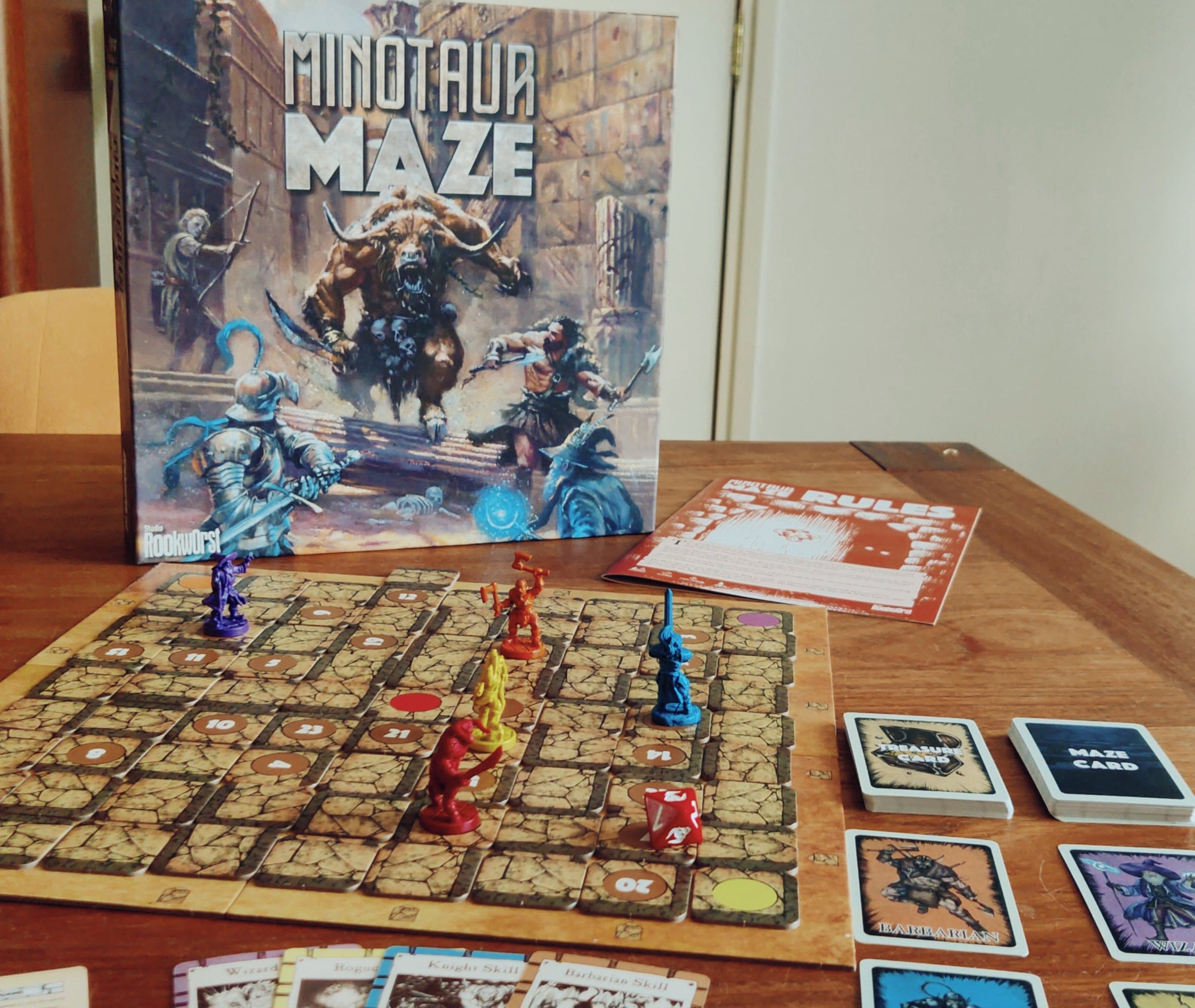 Board game 'Minotaur Maze' with pieces and cards on a wooden table